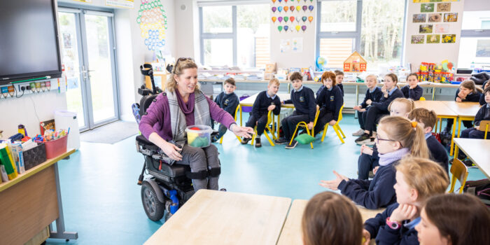 woman in wheelchair in classroom with children