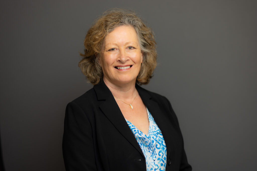A woman in business attire against a grey background. Jackie Harrison is Director of Philanthropy at Community Foundation Ireland. 