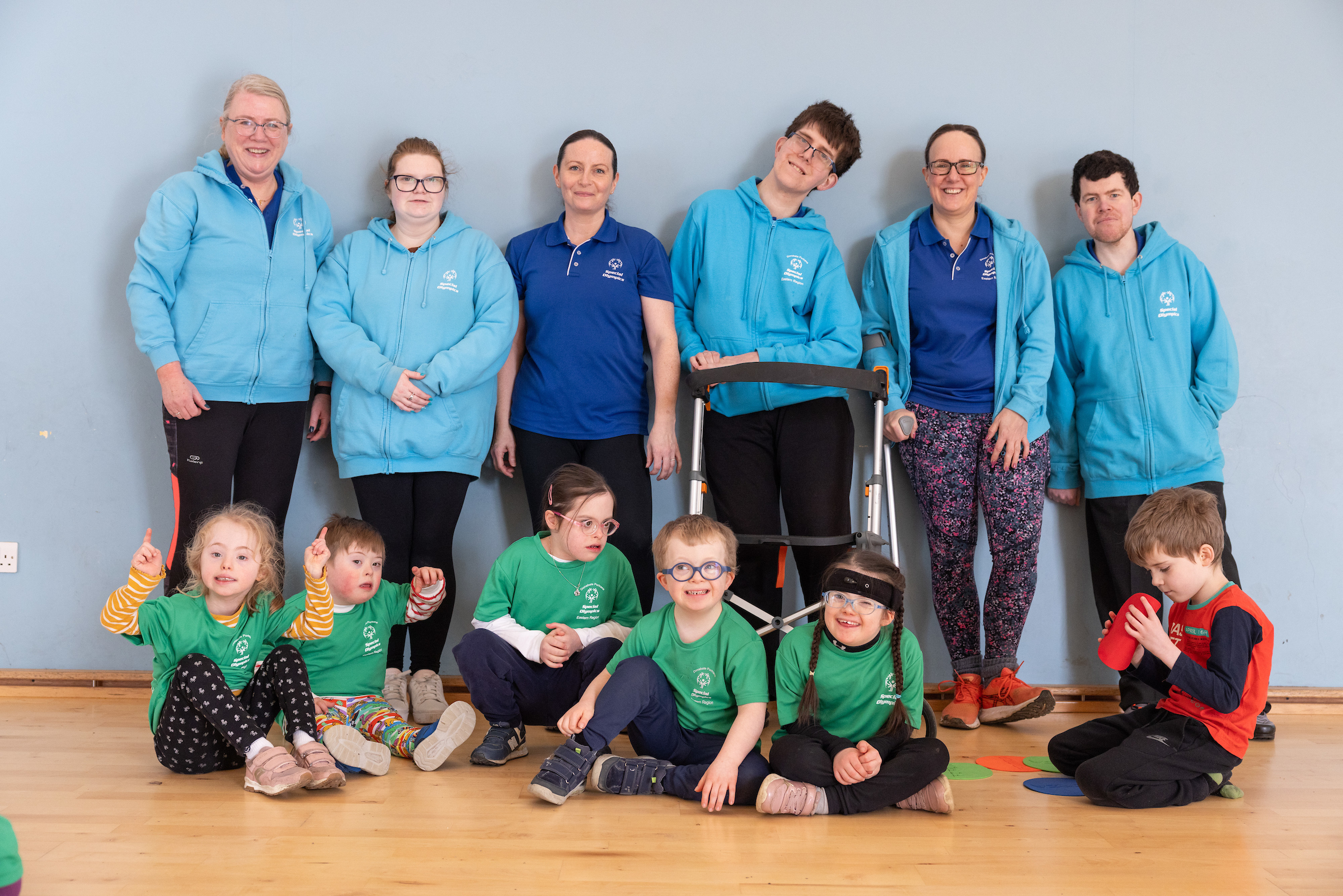 Six staff members posing with six children participating in the course