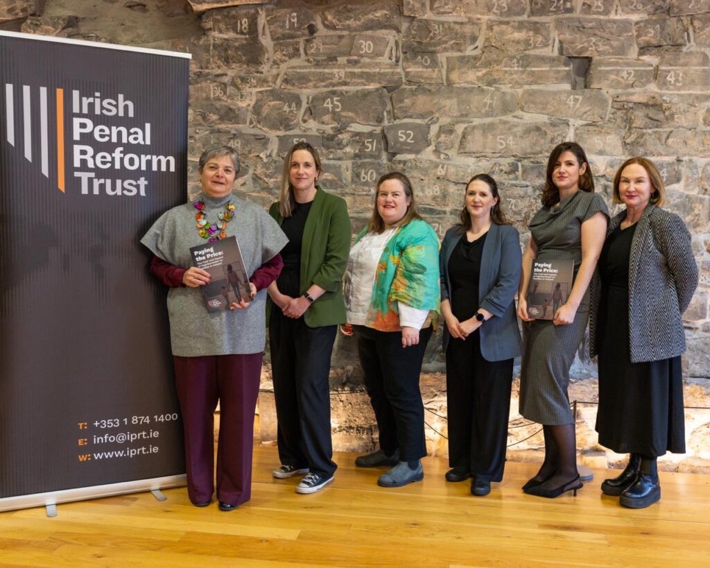 The six speakers at the launch of Paying the Price all lined up against a pop banner with the logo of then Irish Penal Reform Trust.