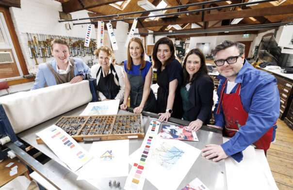 Partners of the 2026 Business to Arts Awards gather in an artists studio. Six representatives are around a work desk or space.